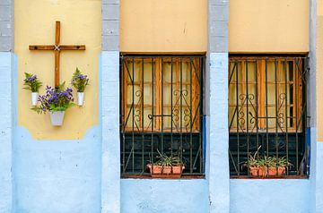 Colourful house facade with cross and flowers by Alexander Baumann