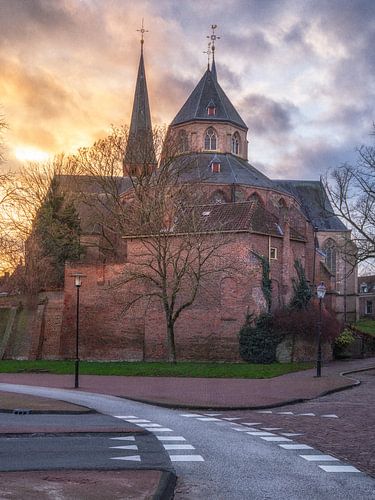 The Bergkerk in the sun with bike path and colourful clouds