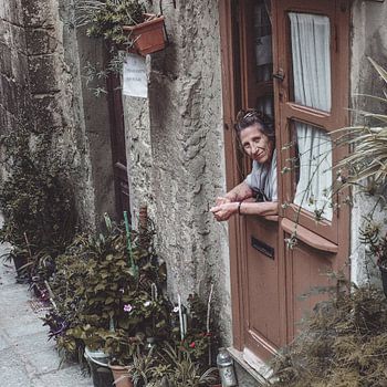 Vrouw kijkt uit haar deur