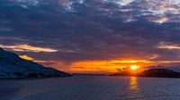 Glorieuze zonsondergang over Noorse kust met besneeuwde rotsen en dichte wolken gezien vanaf open ze van Robert Ruidl thumbnail