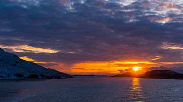 Glorieuze zonsondergang over Noorse kust met besneeuwde rotsen en dichte wolken gezien vanaf open ze van Robert Ruidl