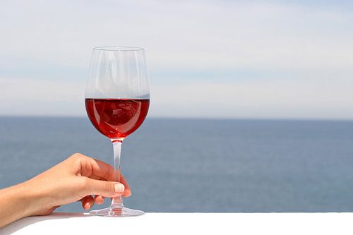 Hand van vrouw met glas rode wijn