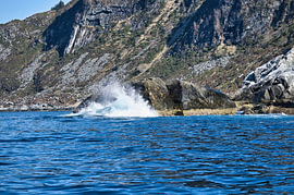 Norway by the fjord, spray on the rocks. Water splashes against the stones. Coastal landscape. by Martin Köbsch