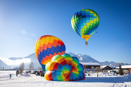 Een heteluchtballon boven een besneeuwd Inzell in Duitsland