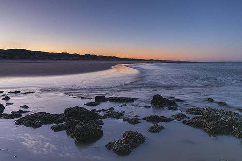 De Nederlandse kust van Den Helder bij zonsopkomst tijdens een koude winterochtend.