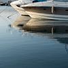 Sailboats reflected in calm sea water 1 by Adriana Mueller