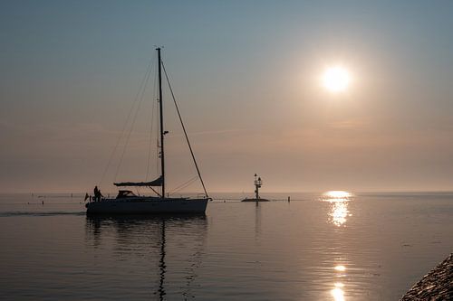 Sailing ship sails out of the harbor.