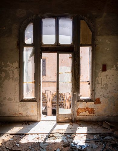Fenster in verlassenem Gebäude mit Sonnenlicht.