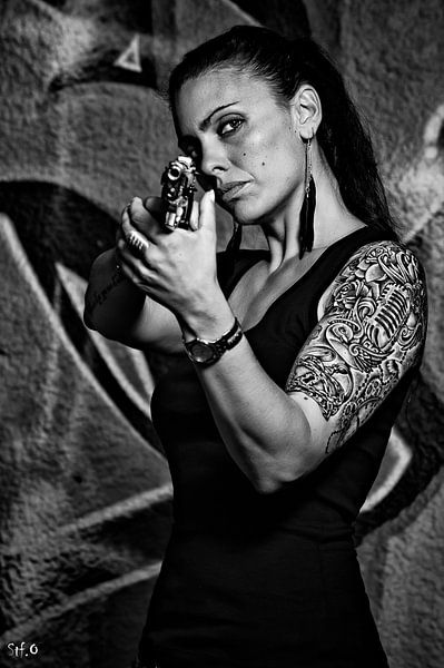 Tätowierte Frau mit einer Pistole in Schwarzweiss von Atelier Liesjes