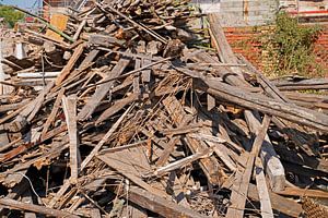 Holzbalken und Bretter auf der Baustelle nach dem Abriss eines Gebäudes