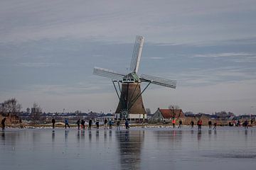 winter landscape with mill and skaters by Cees Kraijenoord