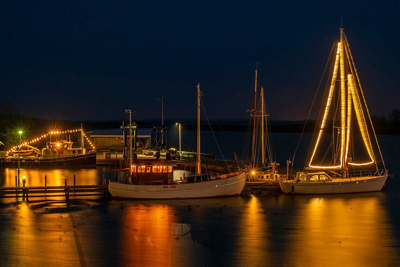 Decorated sailing boats at Christmas in the harbour of Lauwersoog in the Netherlands at sunset by Eye on You