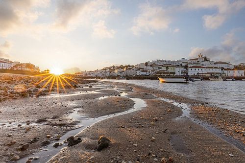 Zandstrand in de ochtend met uitzicht op het historische centrum van Ferragudo, Portimão, Algarve, Portugal