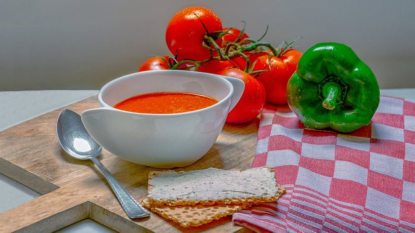 Tomatoes Paprika soup on a wooden cutting board by R Smallenbroek