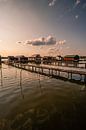 Steg im See zum sonnenuntergang mit Häusern von Fotos by Jan Wehnert Miniaturansicht