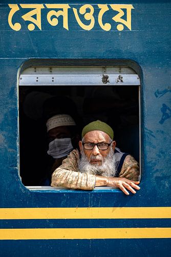 Man looks out window on train