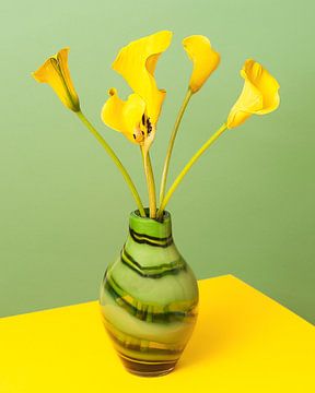 Calices d'Aron jaune dans un vase vert