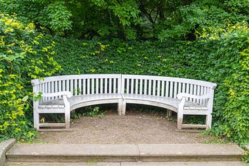 Witte tuinbank voor een weelderige achtergrond van heggen van Alexander Baumann