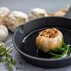 Gepofte knoflook in een gietijzeren pan van Miranda van Hulst