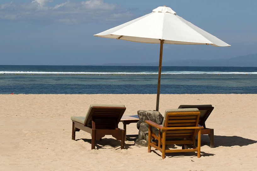 Parasol with sun loungers on the beach of Sanur in Bali by Maurice de vries