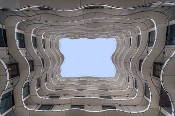 Omhoog kijken naar de verschillende lijnen en vormen van een appartementencomplex van Bob Janssen