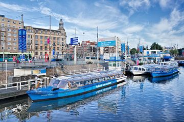 Early morning scene with blue sky and tour boats Amsterdam  by Tony Vingerhoets