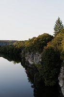 Spiegeling van de rotsen in de Franse Ardeche rivier tijdens de zonsondergang.