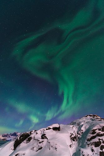 Noorderlicht of Aurora Borealis over de besneeuwde bergen in de winter