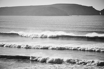 Surfers in de golven in zwart wit