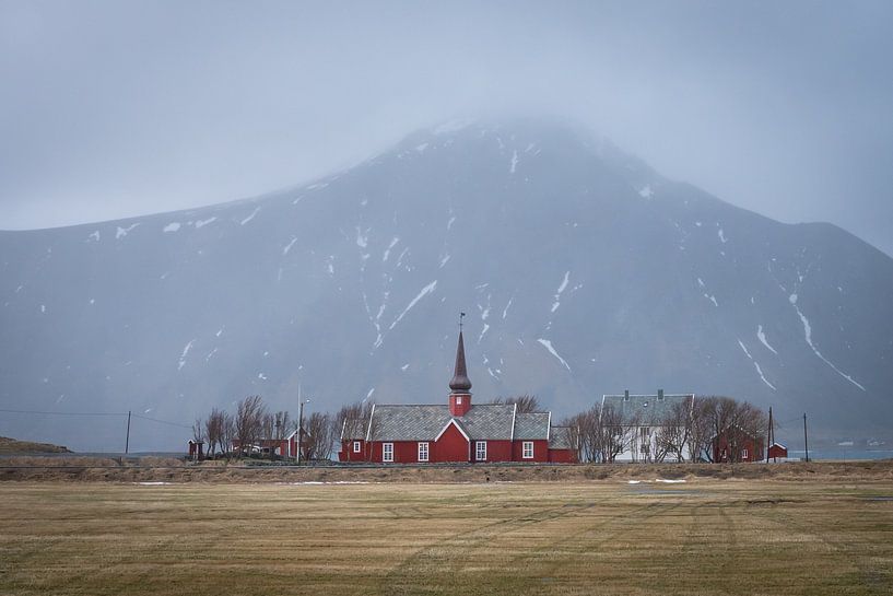 Norwegian red church with mountain in background on Lofoten Islands by Margreet Riedstra
