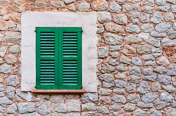 Grüne geschlossene Fensterläden und rustikale Steinmauer von Alex Winter