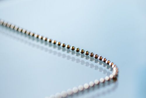 Metalen ketting op glasplaat met dubbele spiegeling