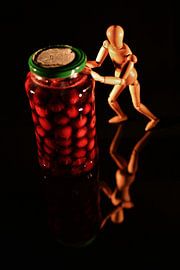 Canned fruit with wooden doll and black background by Hans-Jürgen Janda