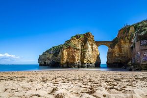 Sonnenuntergang am Praia da Caldeira. Klippen eine brücke über dem Meer einer Bucht bei Lagos, Portuga