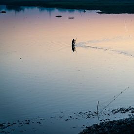 Fischer zieht sein Fischernetz durch das Wasser bei Mandalay Myanmar. von Twan Bankers