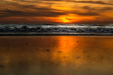 Reflexion der untergehenden Sonne auf dem Strand von Noordwijk