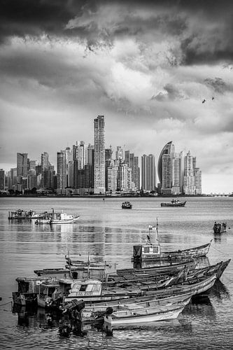 Traditional boats bobbing in front of modern Panama City