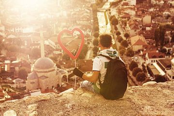 Teenager mit Herzballon in der Hand schaut zur Stadt hinunter von Besa Art