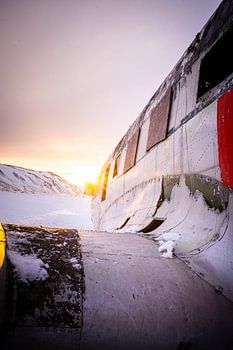 DC-3 vliegtuigwrak in besneeuwd landschap bij zonsondergang, Eyvindarholt, IJsland