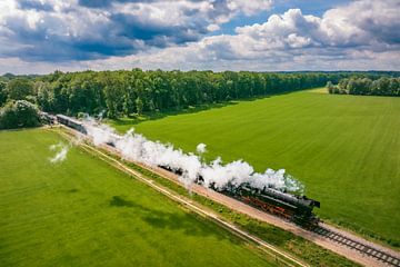 Stoomtrein met rook van de locomotief rijdt door het landschap van Sjoerd van der Wal