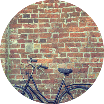 Grootmoeder fiets  staat tegen een oude bakstenen muur