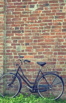 Großmutters Fahrrad steht an einer alten Backsteinmauer