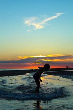 Surfen in Zeeland bij zonsondergang. van Jos Wielemaker