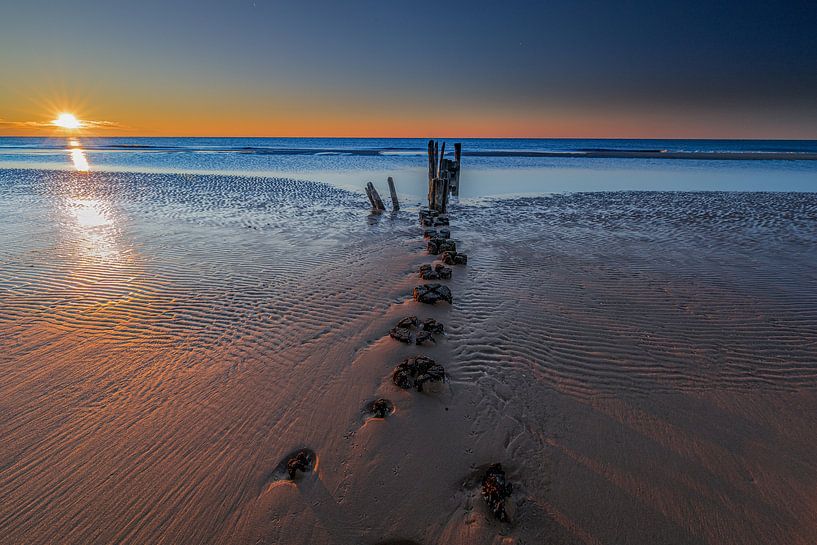Golfbreker bij zonsondergang van peterheinspictures