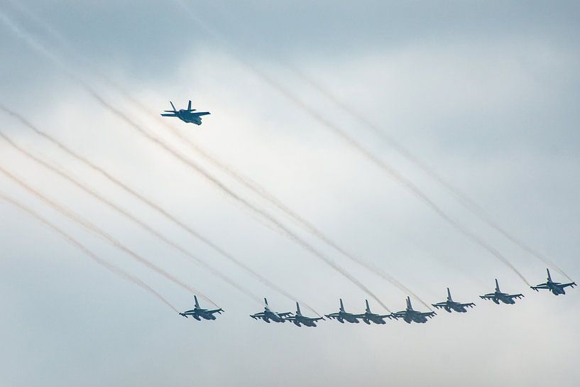 F16 gevecht vliegtuigen in formatie met de F35 er achter vliegend. van Brian Morgan