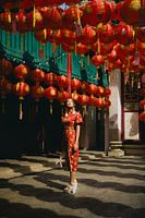 Solemn elegance in Asia: woman in a cheongsam under red lanterns