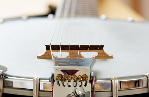 Detail eines metallischen Banjos mit 6 Saiten als Musikhintergrund, ausgewählter Fokus und enge Schä