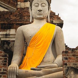 Boeddhabeeld met geel/oranje tinten in Thailand van Travelaar