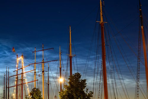 Navires amarrés à la rivière IJssel à Kampen avec des nuages noctilucides.