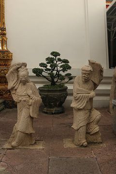Stenen beelden van Aziatische vrouwen en mannen bij Wat Pho Buddha tempel. van kall3bu